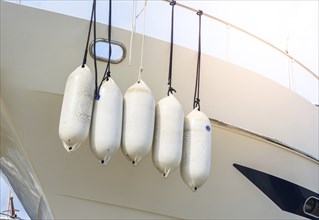 Yacht with white hanging buoys