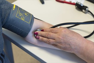 The doctor measures pressure at a teenager