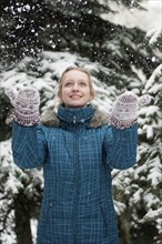 A girl in a pine forest during a snowfall