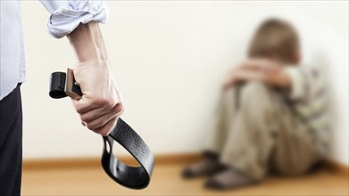 Family violence and aggression concept, furious angry man raised punishment hand holding leather