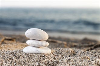 Stability and harmony, stack or pile of balancing rock stones on summer vacations sea sun beach