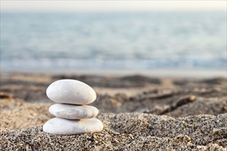 Stability and harmony, stack or pile of balancing rock stones on summer vacations sea sun beach