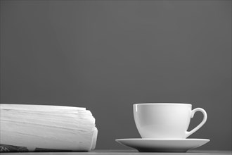 White mug and newspaper on a gray background