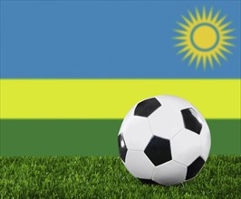 The Rwanda flag and soccer ball on the green grass