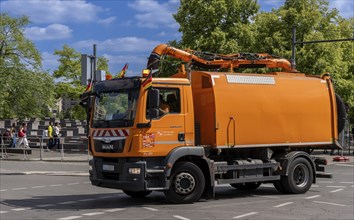 Operational vehicle of the Berlin city cleaning service with German flags on the driver's cab,