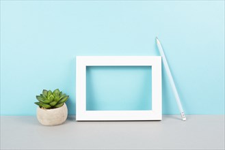 Home interior poster mock up with wooden frame, cactus in a pot, blue wall background, copy space