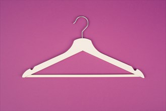 White hanger on a pink background, fashion store, minimalism clothes, discount promotion