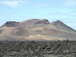 Close-up of a volcano and a lava field under a slightly cloudy sky on Lanzarote, arrecife,