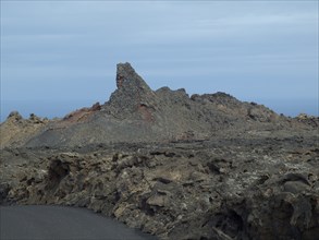 Rough volcanic terrain with dark rocks under a cloudy sky, arrrecife, lanzaorte, canary islands,