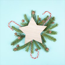 Christmas holiday background with a star, frame with fir branches, pine cones, and candy cane,