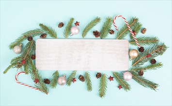 Christmas holiday background, frame with fir branches, baubles, candy cane and cones, winter season