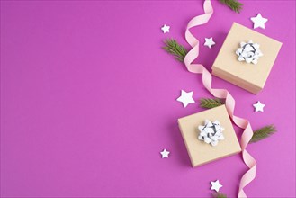 Christmas holiday background with little gift boxes, stars and fir branches, pink trendy background