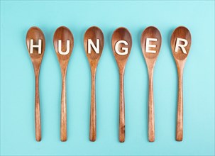 Hungry is standing in german language on the wooden spoons, food shortage and starving because of