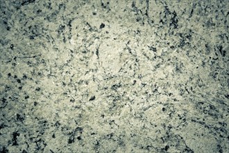 Rough granite texture with gray and black spots, displaying a natural rugged appearance, background