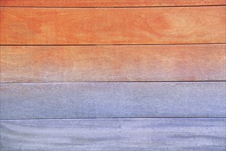 Wooden planks featuring a gradient from warm orange and red tones at the top to cool blue and