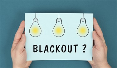 The word blackout is standing under lightbulbs, power cut out, uncertain energy supply