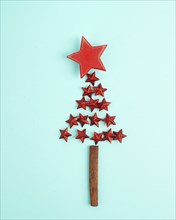 Christmas tree made from red stars and a cinnamon stick as the trunk, winter holiday greeting card