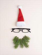 Christmas season, Santa Claus face with a red hat, eyeglasses, beard made from fir twigs,