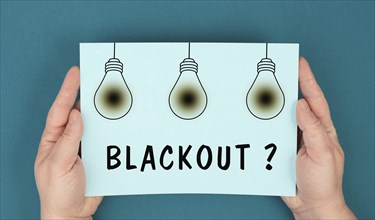 The word blackout is standing under the blown lightbulbs, power cut out, uncertain energy supply