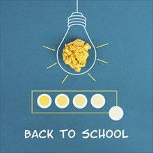 Lightbulb with crumpled paper and a loading bar, the phrase back to school is standing below,