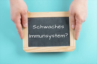 Weak immune system is standing in german language on a chalkboard, healthy eating and lifestyle