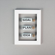 Three glass bottles with the words idea, plan and goal in a frame, education, marketing and