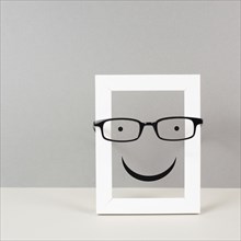 Frame with a happy face with eyeglasses, mental health concept, positive mindset and emotion,