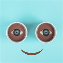 Cup of coffee building the eyes of the funny face, mouth is smiling, wake up in the morning, hot