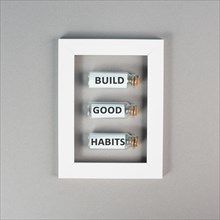 The words build good habits are standing on glass bottles in a frame, change lifestyle, healthy and