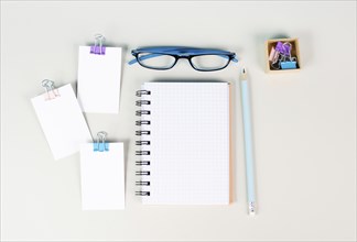 Blank notebook with a pen, paper and eyeglasses on a gray background, brainstorming for ideas,