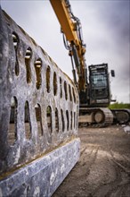 Close-up of a demolition machine with focus on the metal grab, blurred background of a construction