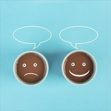 Cup of coffee with a sad and a happy face, positive and negative mindset, support and evaluation