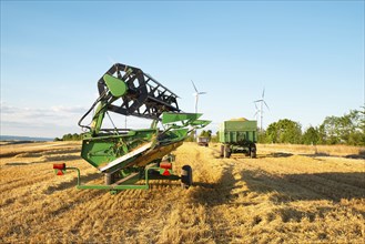 Harvester in a field of cultivated barley in Germany, harvest in the summer, agriculture for food,