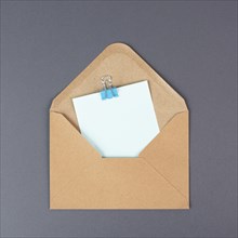 Envelope with an empty paper on a gray colored background, copy space for text, greeting card,