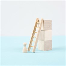 Man is standing next to a ladder, climbing up in career, having a goal, brainstorming for ideas,