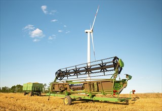 Harvester in a field of cultivated barley in Germany, harvest in the summer, agriculture for food,