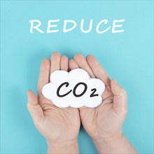 Hand holds cloud with the word CO 2, reduce carbon dioxide emission, environmental issue, air