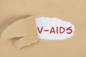 The words v-aids is standing in german language on on torn paper, vaccine damage, new autoimmune