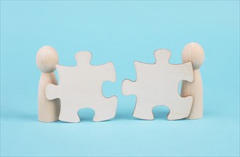 Two men with puzzle pieces built a team, connect the parts together, corporate in teamwork,