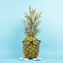 Pineapple with glasses and flip flops, vacation and travel concept, tropical summer holiday, funny