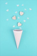 Cone with rose colored hearts, blue background, birthday and valentines day greeting card,