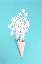 Cone with white puzzle pieces, blue background, spreading the jigsaw parts, searching for ideas and