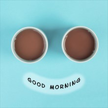 Cup of coffee building the eyes of the funny face, mouth with the phrase good morning, wake up in