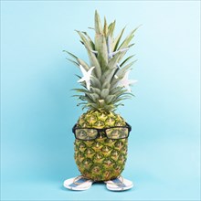 Pineapple with glasses and flip flops, vacation and travel concept, tropical summer holiday, funny