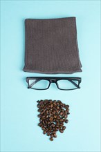 Human face made with a wool hat, glasses and coffee beans as a beard, funny minimalist portrait,