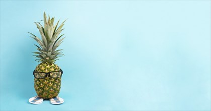 Pineapple with glasses and flip flops, vacation and travel concept, tropical summer holiday, funny