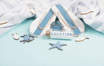 Blue colored summer and holiday background, flippers, sea stars and a glass bootle with the word