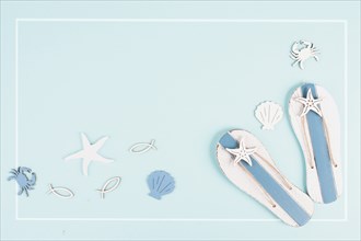 Blue colored summer and holiday background, flip flops, sea stars and fish with copy space, travel