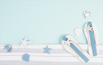 Blue colored summer and holiday background, flip flops, sea stars and fish with copy space, travel