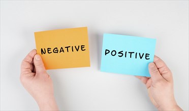 The words negative and positive are standing on paper, business and service rating, evaluation